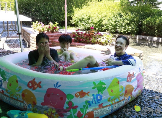 세명의 장애가족들이 물풀에 앉아 물놀이를 즐기고 있다. 장애가족행복지킴이 승가원 CI