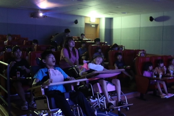 불이 꺼지고 영화가 시작된 영화관에 장애아동들이 가득 채워 앉아있다