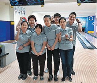 볼링장에서 7명의 장애가족이 사진을 찍기 위해 서있는 모습