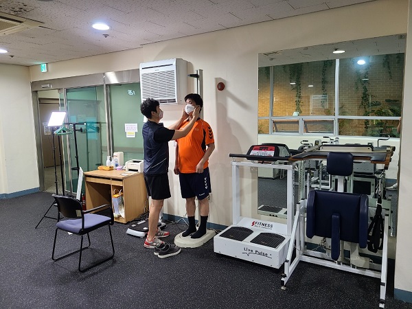 성북어벤져스 사업에 참여한 이용인과 생활체육교사가 기계를 사용해 신체수치를 측정하고 있는 모습