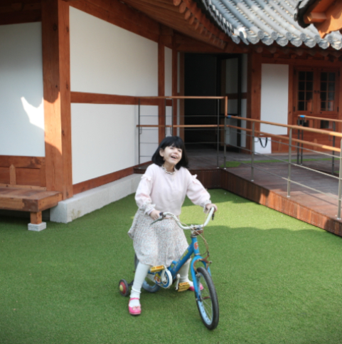 여자장애아동이 자전거를 타며 웃고있는 모습