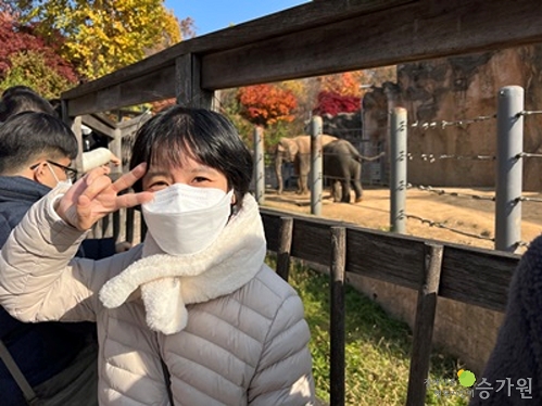 동물원 코끼리 앞에서 브이를 하고 있는 장애가족 / 장애가족행복지킴이 승가원 CI