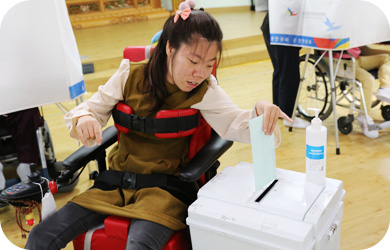 휠체어에 안자 투표하는 모습