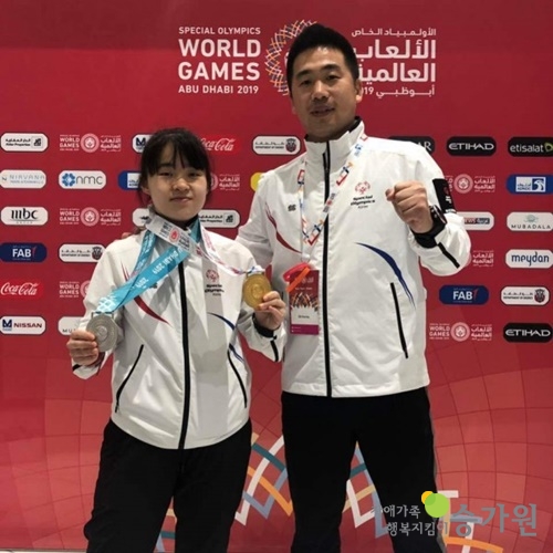 스페셜올림픽에서 금메달을 수상한 문지연선수 그리고 그 옆에 함께 서있는 남자 직원