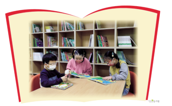 승가원행복마을 도서관에서 책을 읽고 있는 세명의 장애아동들