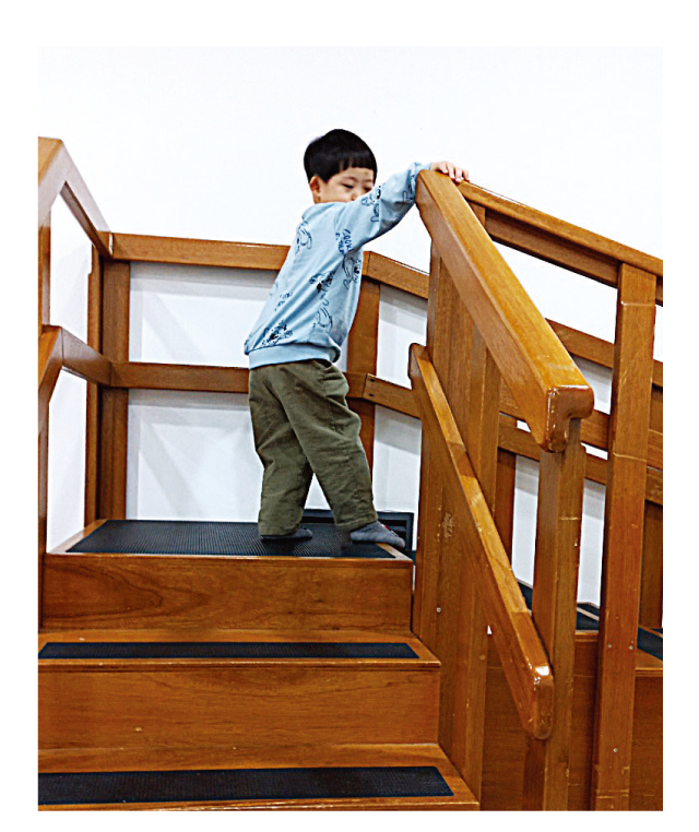 계단을 오르고 있는 장애아동 1명의 사진