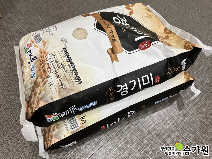 김진백 후원가족님의 후원물품(경기미 20kg, 10kg 쌀 2포대가 쌓여있다), 우측 하단 장애가족 행복지킴이 승가원ci 삽입